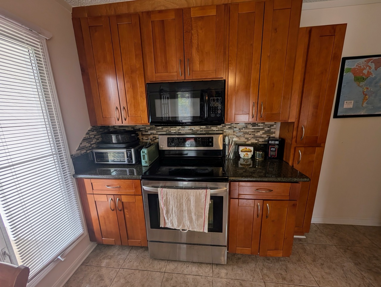 Kitchen appliances at Hauʻula Hideaway including range, microwave, and cabinetry